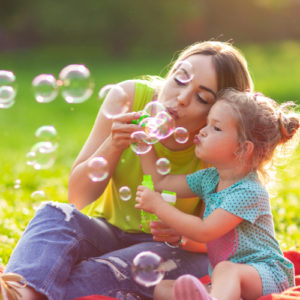 Mother and daughter blowing bubbles