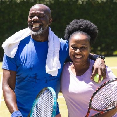 coupletennis Couple posing with tennis equipment