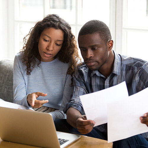 Couple with documents in front of their computer